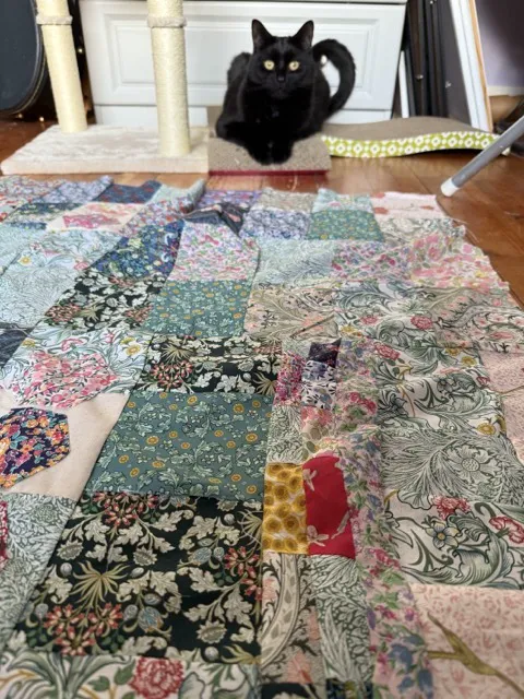 Fabric squares laid out for a patchwork quilt.